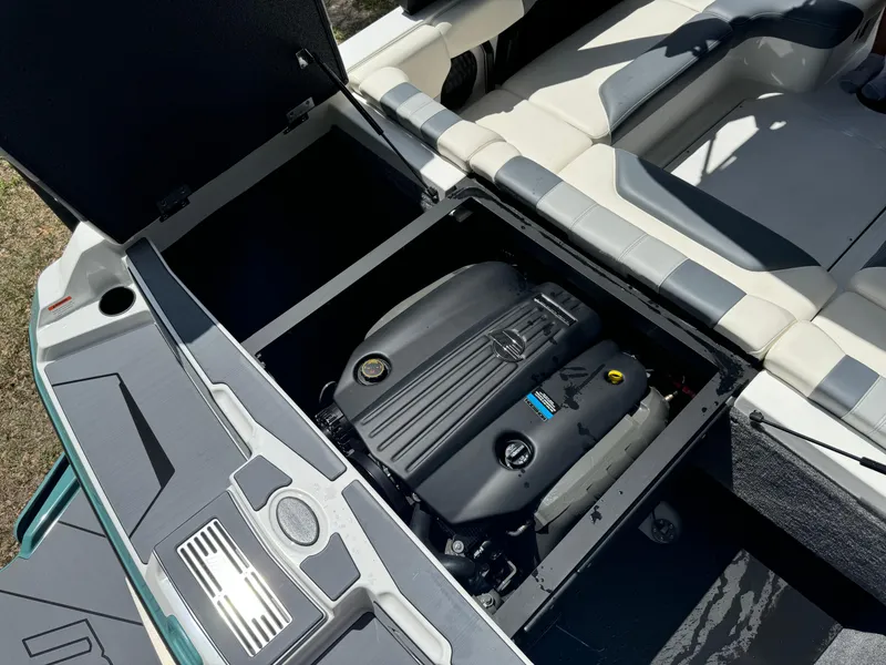 Slide: The Image of 2024 Malibu LX-R boat engine compartment with open hatch and seating area. - 27