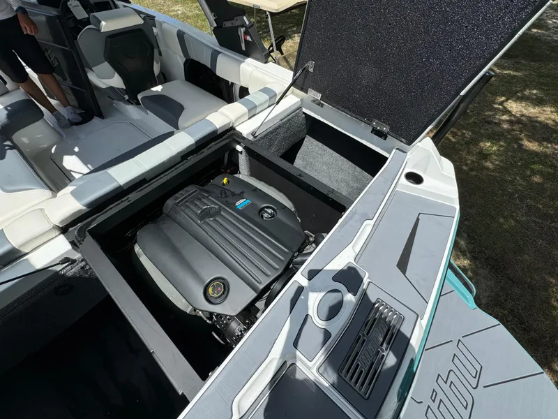 Slide: The Image of 2024 Malibu LX-R boat engine compartment with open hatch and seating area. - 28