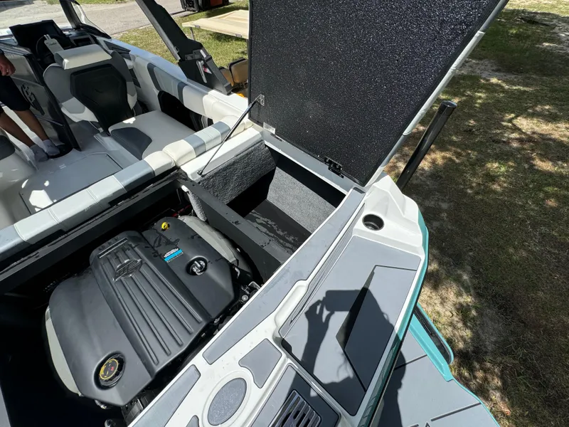 Slide: The Image of 2024 Malibu LX-R boat engine compartment with open hatch and seating area. - 29
