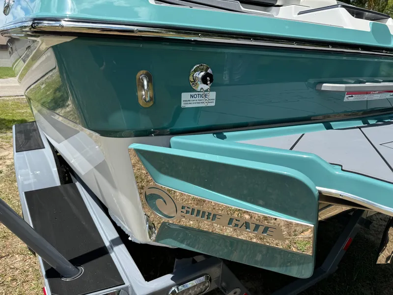 Slide: The Image of 2024 Malibu LX-R boat with Surf Gate technology, teal and white exterior. - 33