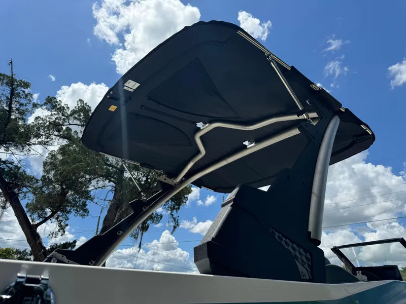 Slide: The Image of 2024 Malibu LX-R boat with canopy against blue sky and clouds. - 36