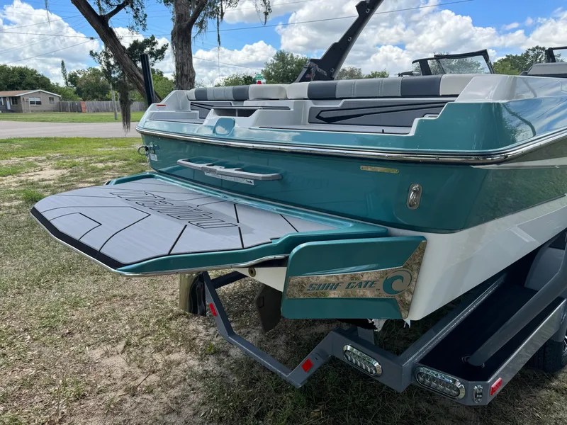 Slide: The Image of 2024 Malibu LX-R boat rear view with swim platform and trailer. - 37