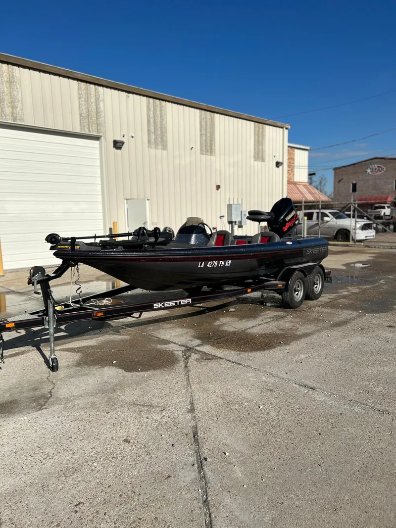 Slide: The Image of 2003 Skeeter SX200 boat interior with Yamaha VMAX engine, featuring gray and red seating. - 2