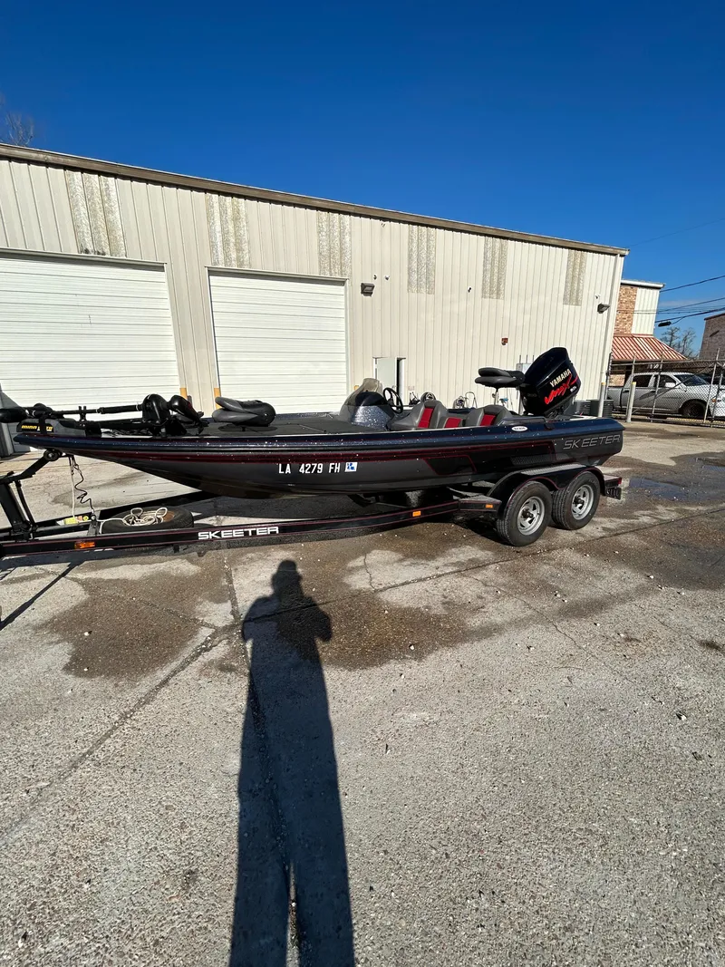 Slide: The Image of 2003 Skeeter SX 200 boat parked outside a garage on a sunny day. - 5