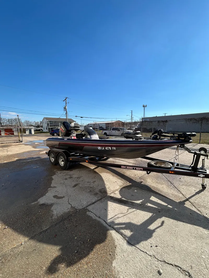 Slide: The Image of 2003 Skeeter SX 200 fishing boat with red and gray seats in a marina. - 9