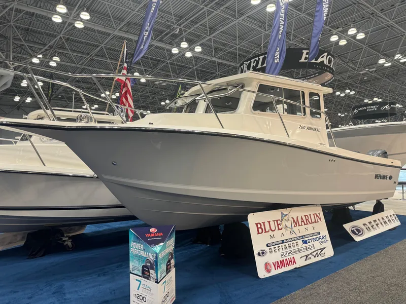 Slide: The Image of 2024 Defiance 260 Admiral EX boat on display in an indoor arena. - 2