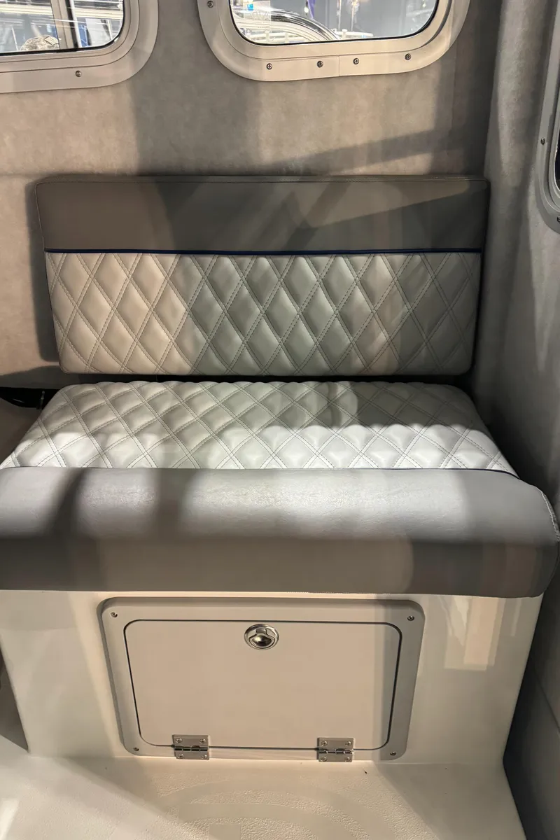 Slide: The Image of 2024 Defiance 260 Admiral EX interior seating with quilted upholstery and storage compartment. - 23