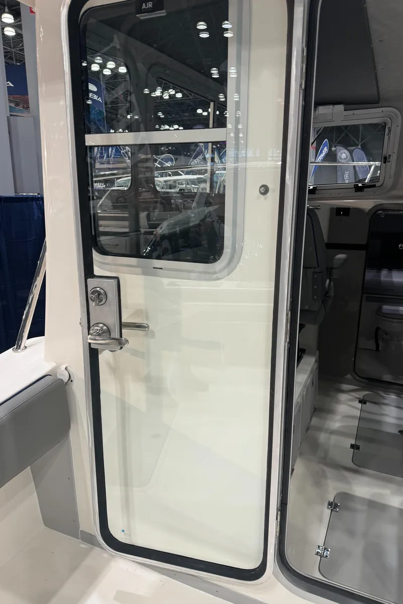 Slide: The Image of 2024 Defiance 260 Admiral EX boat interior with steering wheel and Garmin navigation system. - 16