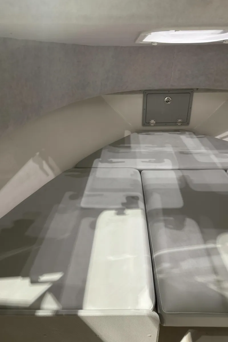 Slide: The Image of 2024 Defiance 260 Admiral EX boat interior with grey seating and storage compartments. - 33