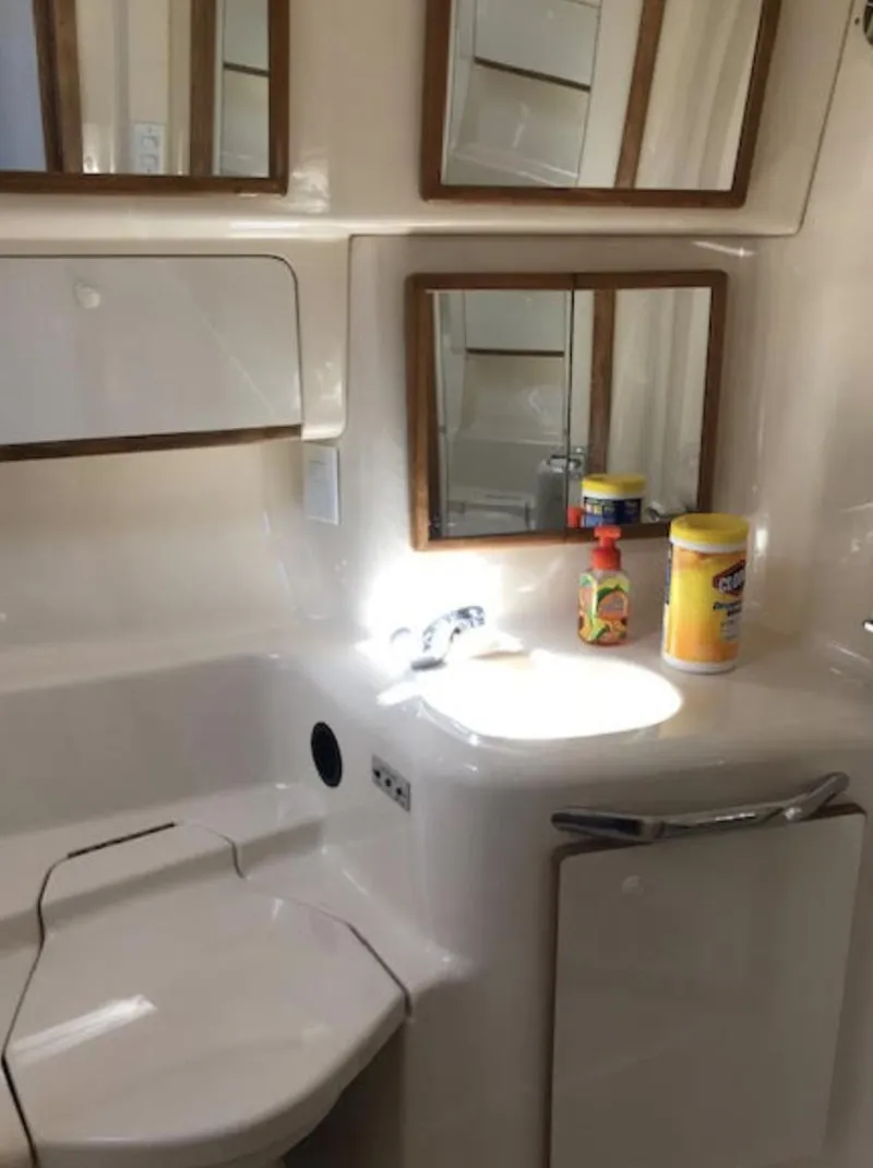 Slide: The Image of 1996 Sea Ray 450 Sundancer bathroom with sink, mirror, and cleaning supplies. - 2