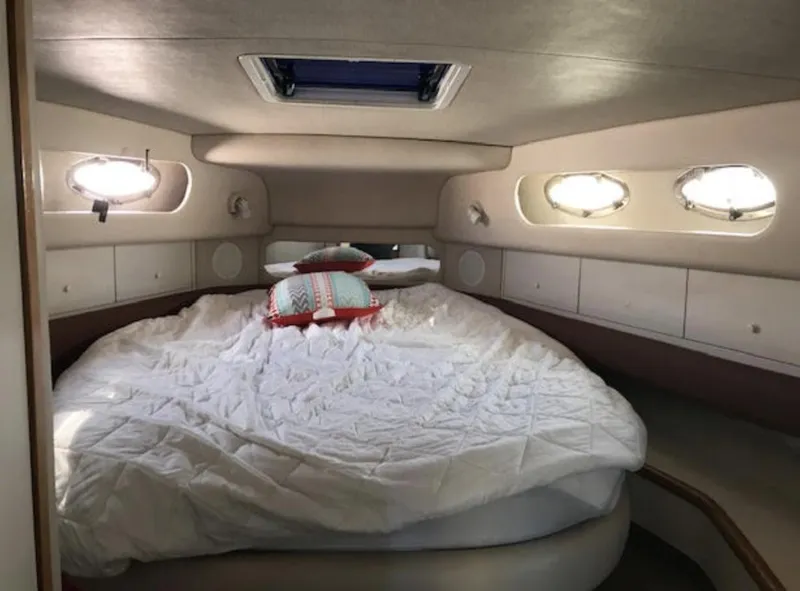 Slide: The Image of Interior cabin of 1996 Sea Ray 450 Sundancer with cozy bed and porthole windows. - 4