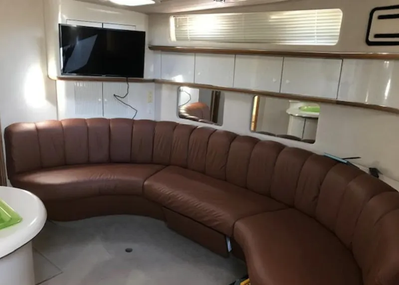 Slide: The Image of Interior of 1996 Sea Ray 450 Sundancer with brown leather seating and mounted TV. - 9