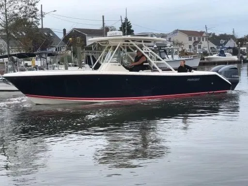 The Image of 2012 Pursuit 280 boat cruising in a marina with houses in the background. - 0
