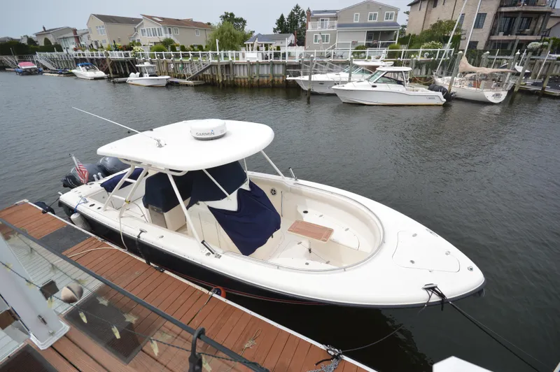 Slide: The Image of 2012 Pursuit 280 boat docked in a marina with waterfront homes. - 1