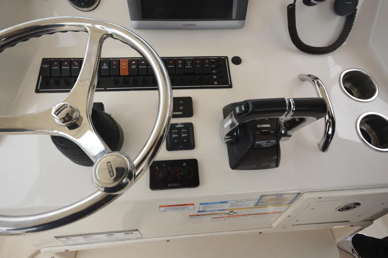 Slide: The Image of Control panel of a 2012 Pursuit 280 boat with steering wheel and throttle. - 15