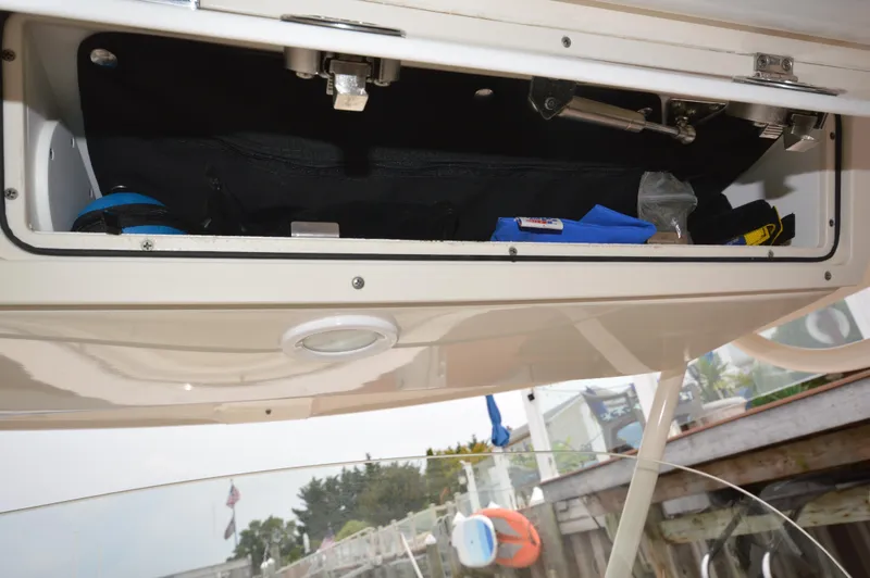 Slide: The Image of Storage compartment of a 2012 Pursuit 280 boat with various items inside. - 17