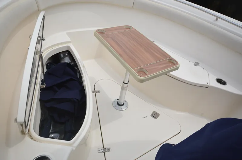 Slide: The Image of 2012 Pursuit 280 boat interior with storage compartment and table. - 19