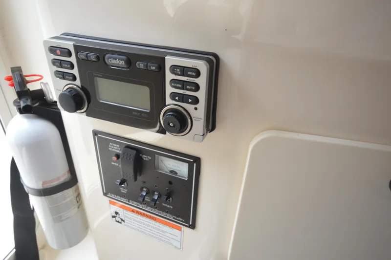Slide: The Image of Control panel and fire extinguisher on a 2012 Pursuit 280 boat. - 24