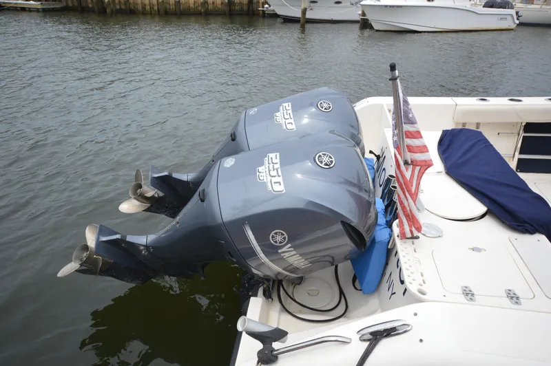 Slide: The Image of 2012 Pursuit 280 boat with twin Yamaha outboard engines docked, displaying an American flag. - 26
