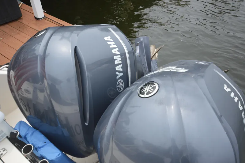Slide: The Image of Twin Yamaha outboard engines on a 2012 Pursuit 280 boat docked by the water. - 10