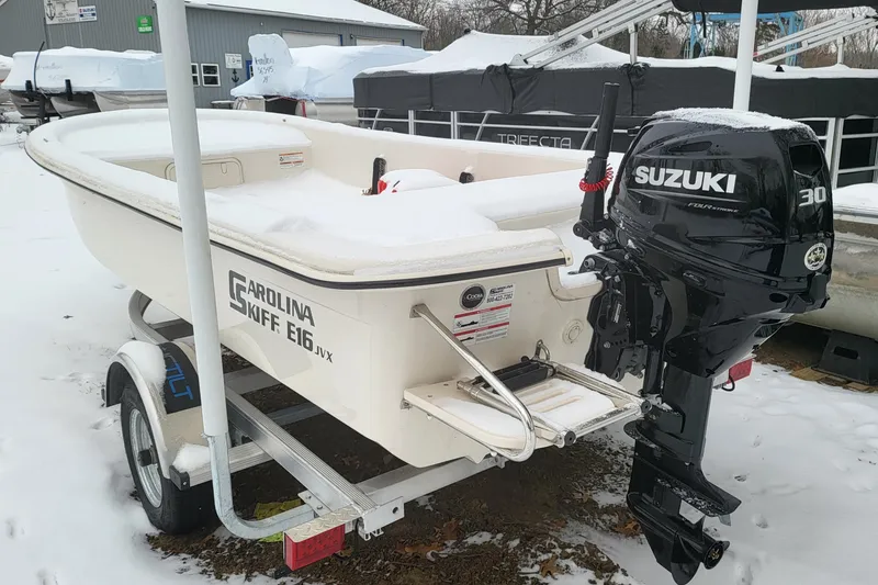 The Image of 2024 Carolina Skiff E16 JVX boat with Suzuki 30 outboard motor in snowy setting. - 0