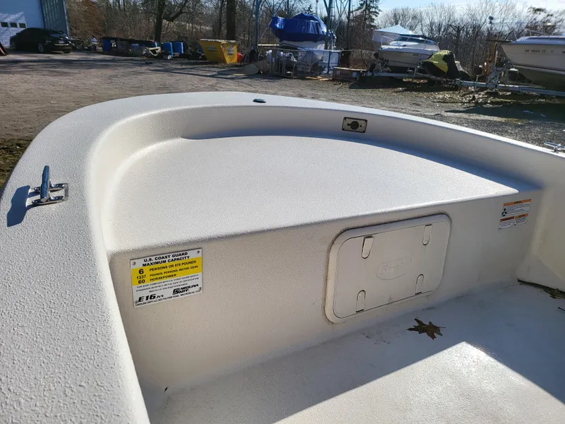 Slide: The Image of 2024 Carolina Skiff E16 JVX TH boat interior, showing storage compartment and clean deck. - 14