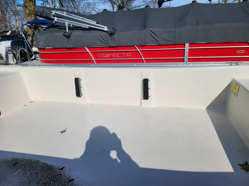 Slide: The Image of 2024 Carolina Skiff E16 JVX TH boat interior with a covered red Trifecta pontoon in the background. - 16