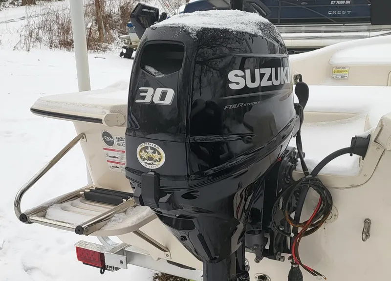 Slide: The Image of 2024 Carolina Skiff E16 JVX TH with Suzuki 30 outboard motor in snowy setting. - 2