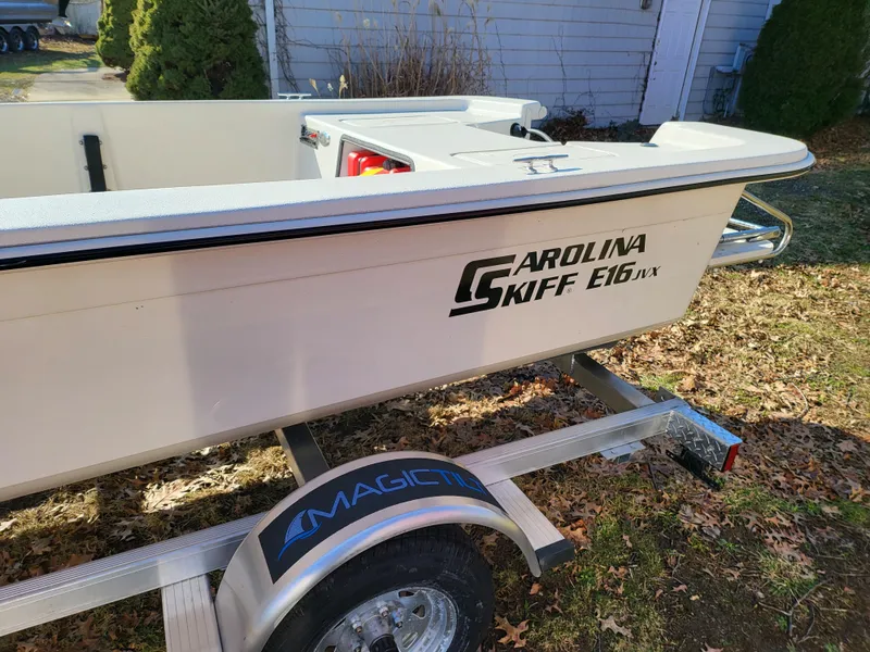 Slide: The Image of 2024 Carolina Skiff E16 JVX TH boat on a trailer in a yard. - 6