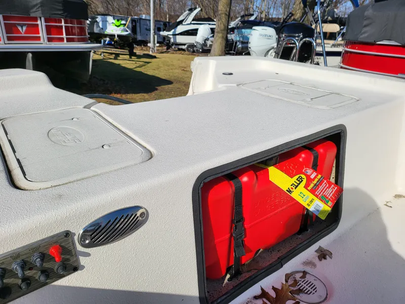 Slide: The Image of 2024 Carolina Skiff E16 JVX TH boat with red fuel tank and storage compartments. - 9