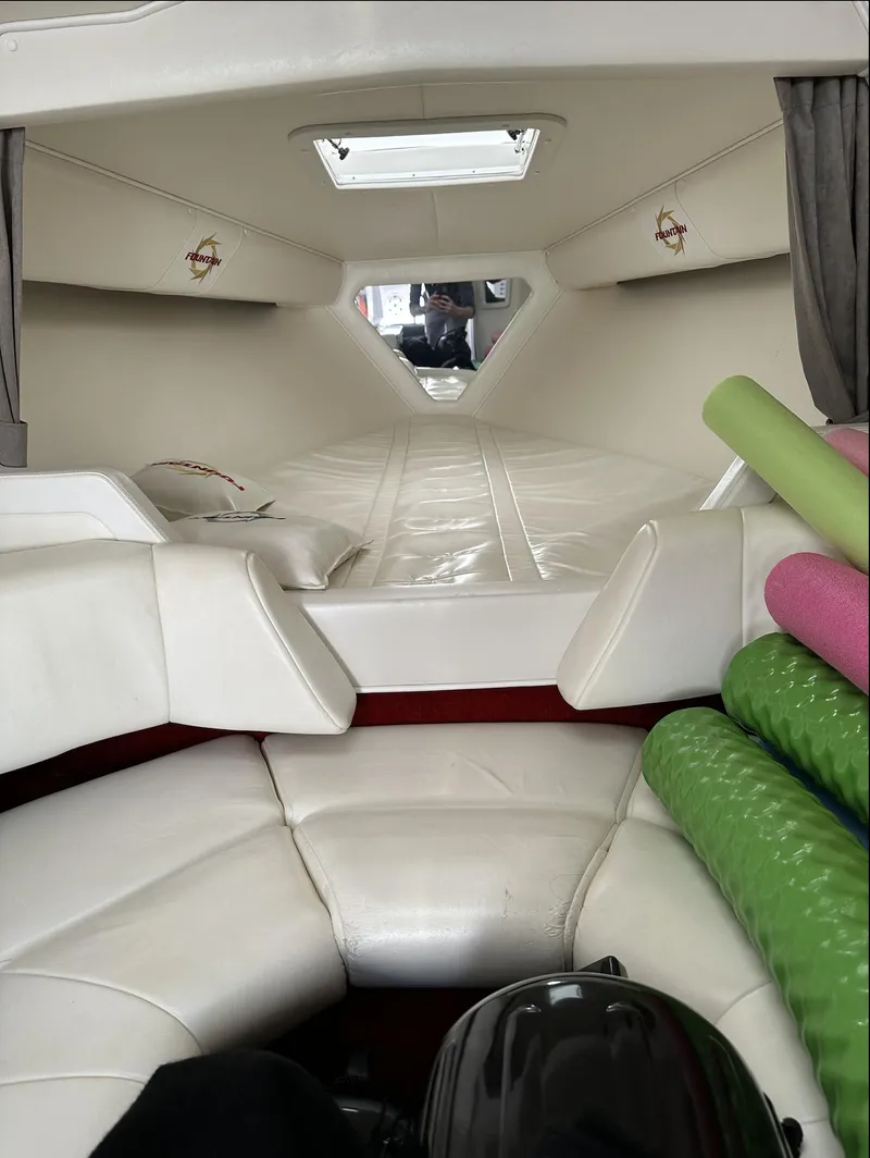 Slide: The Image of Interior cabin of a 2003 Fountain 38 Lightning boat with white seating and green mats. - 19