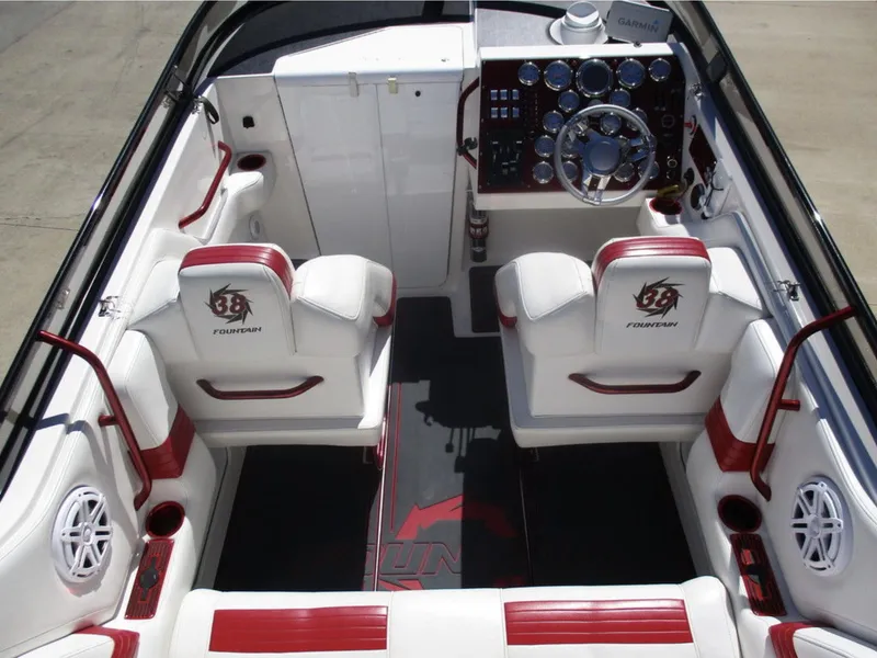 Slide: The Image of 2003 Fountain 38 Lightning boat interior with red and white seating, steering wheel, and control panel. - 9