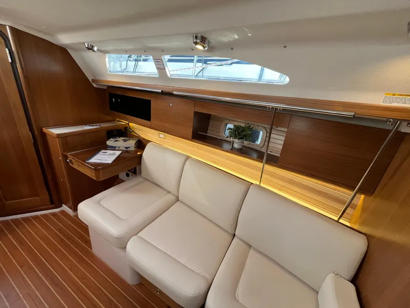 Slide: The Image of Interior of 2024 Catalina 355 sailboat with modern wood finish and white leather seating. - 13