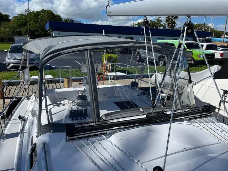 Slide: The Image of 2024 Catalina 355 sailboat with cockpit enclosure, docked under a partly cloudy sky. - 4