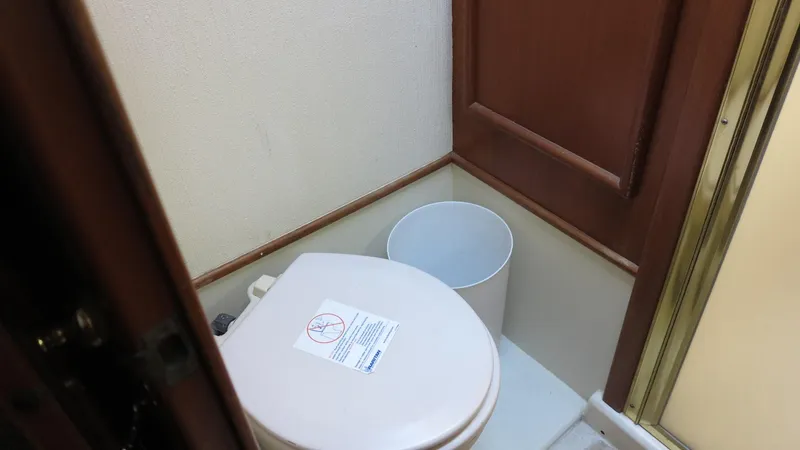 Slide: The Image of 1986 Post Sportfisher boat bathroom with toilet and waste bin. - 15