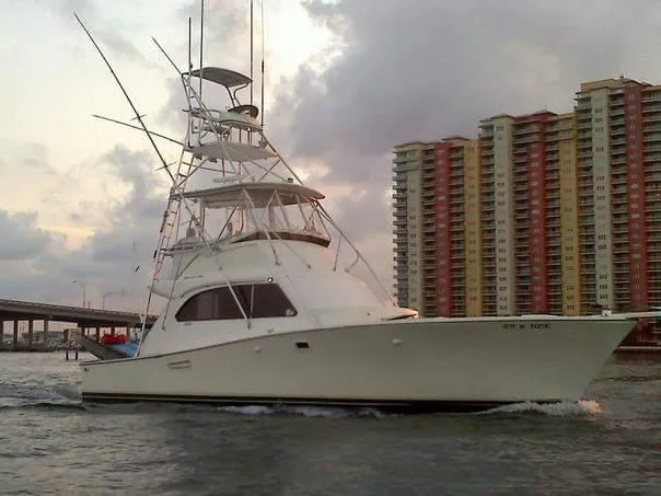 The Image of 1986 Post Sportfisher yacht cruising near high-rise buildings. - 0