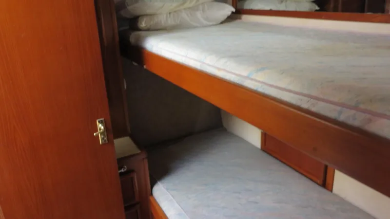 Slide: The Image of 1986 Post Sportfisher cabin with wooden bunk beds and storage. - 13