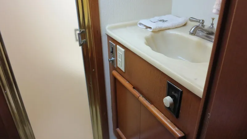 Slide: The Image of 1986 Post Sportfisher bathroom sink with wooden accents and towel. - 14