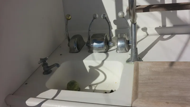 Slide: The Image of 1986 Post Sportfisher boat controls and sink area in sunlight. - 23