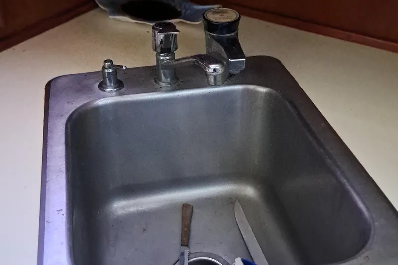 Slide: The Image of 1986 Post Sportfisher boat sink with faucet and utensils. - 38