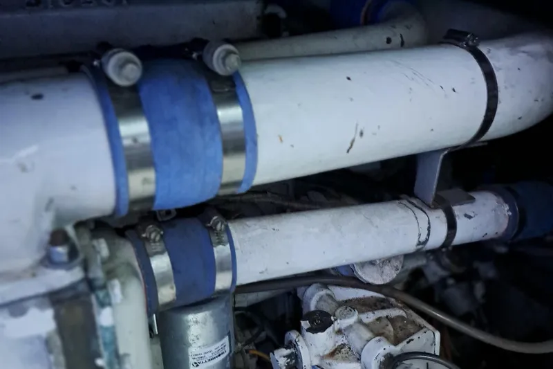 Slide: The Image of Engine compartment of a 1986 Post Sportfisher boat with visible pipes and clamps. - 48