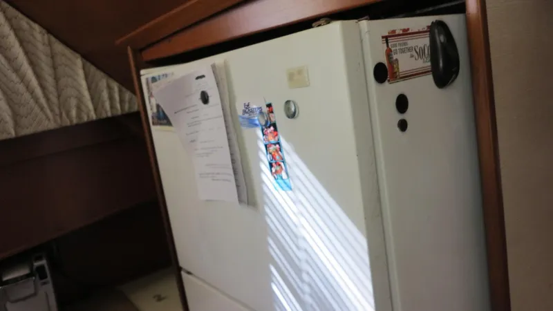 Slide: The Image of 1986 Post Sportfisher interior with fridge and documents attached. - 7