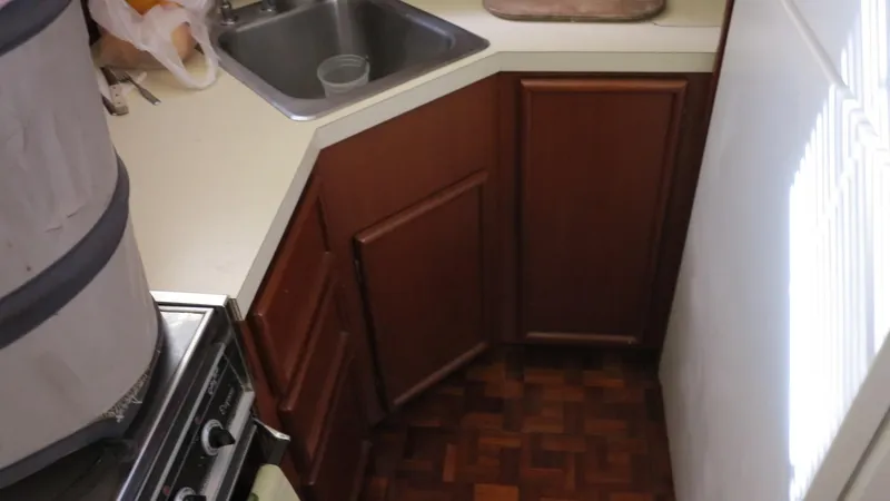 Slide: The Image of 1986 Post Sportfisher kitchen with wood cabinets, sink, and stove. - 8