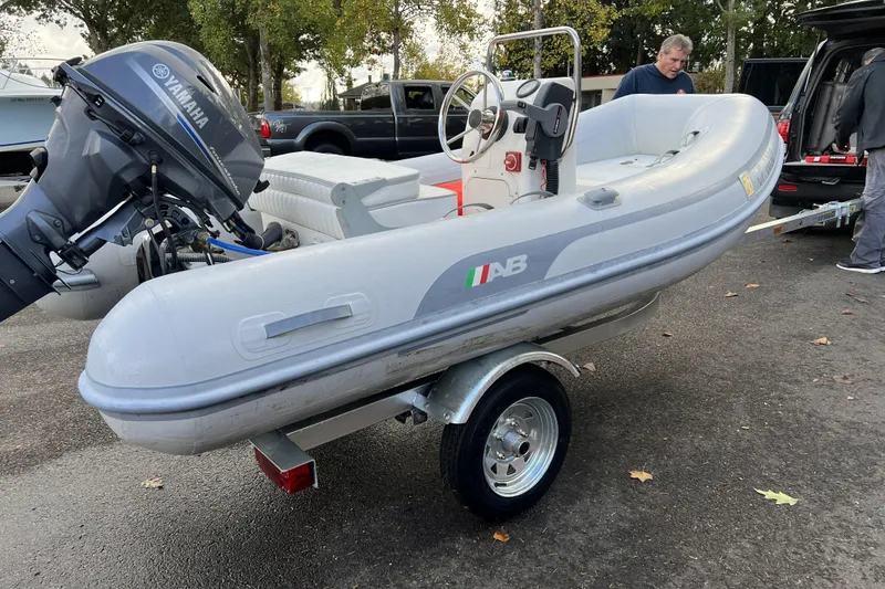 Slide: The Image of Inflatable boat with Yamaha motor on trailer, parked outdoors. - 68
