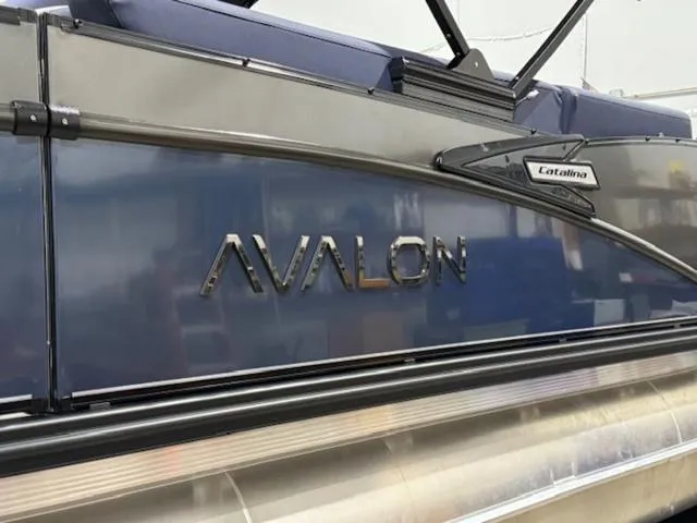 Slide: The Image of 2024 Avalon Catalina Rear J Lounger 23 FT pontoon boat, side view with logo. - 4