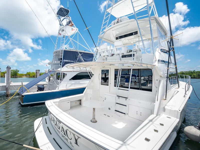 Slide: The Image of 1992 Hatteras 50 Convertible yacht docked at marina under blue sky. - 11
