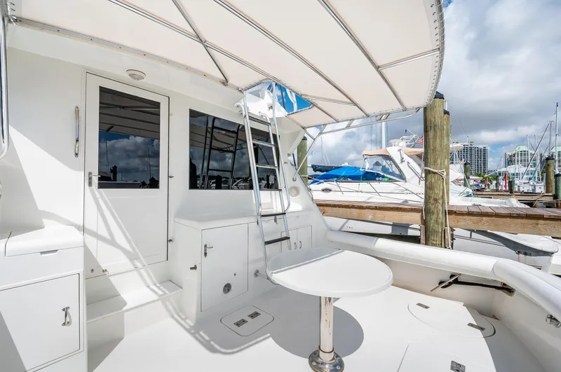 Slide: The Image of 1992 Hatteras 50 Convertible yacht deck with seating and marina view. - 18