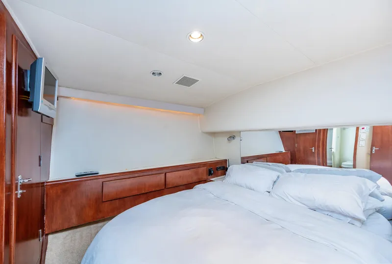 Slide: The Image of 1992 Hatteras 50 Convertible yacht bedroom with cozy bed and wooden cabinetry. - 25