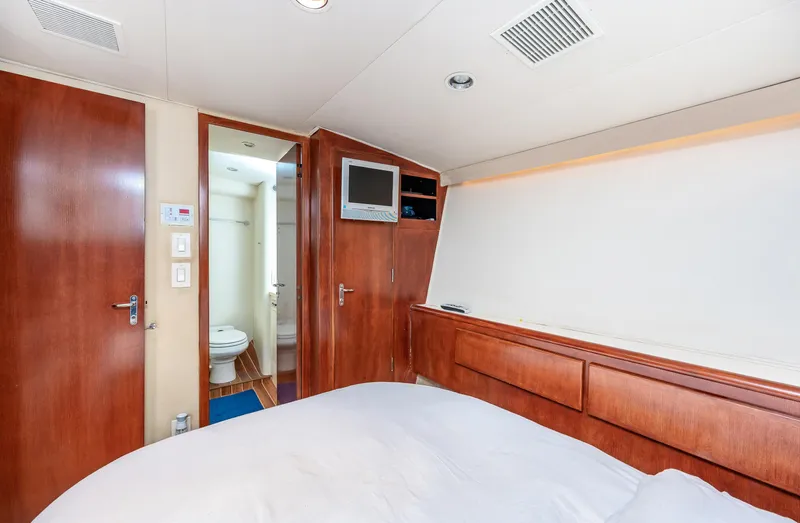 Slide: The Image of 1992 Hatteras 50 Convertible yacht bedroom with ensuite bathroom and wooden cabinetry. - 26