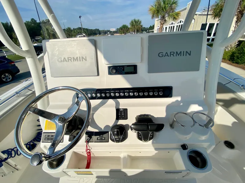 Slide: The Image of 2022 Key West 263 FS boat dashboard with Garmin navigation systems and steering wheel. - 23